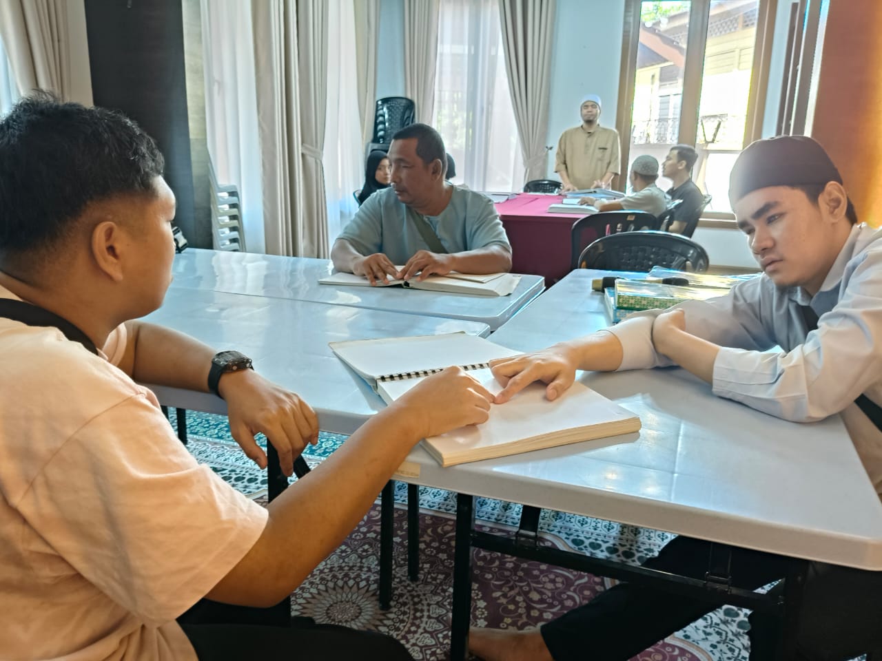 Ahli PERTIS mengikuti kelas bacaan Al-Quran Braille berhampiran ruang Mini Perpustakaan