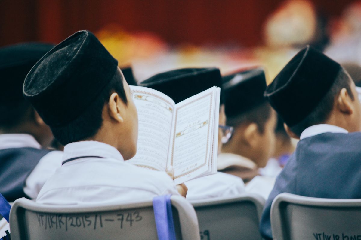 Pelajar membaca Al-Quran semasa kelas pengajian fardhu ain (imej stok)